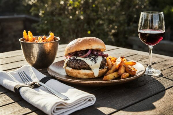 Burger mit Rindfleisch und geschmolzenem Blauschimmelkäse, karamellisierten Zwiebeln und Rotwein aus Kanada